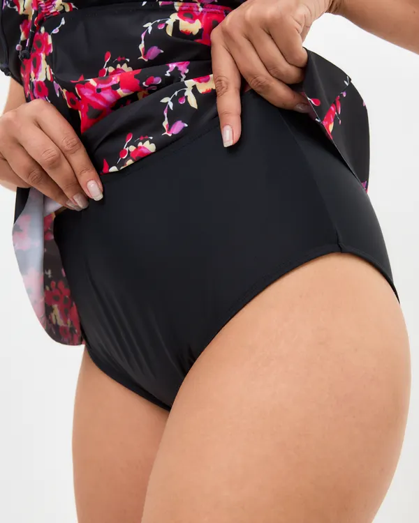 Hand lifting the Inga top to show the black high-waisted bottom